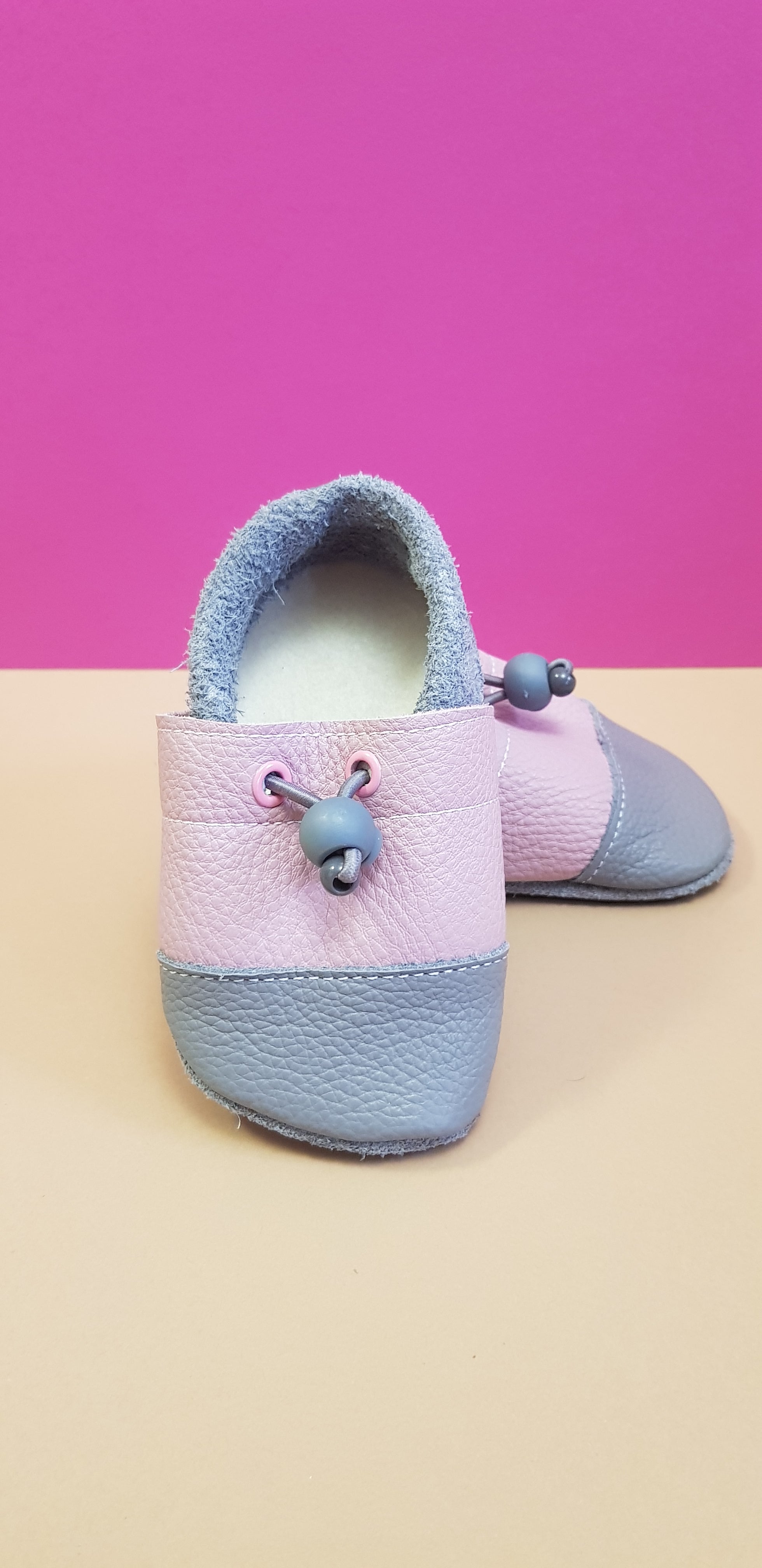 Pink and Grey Nohatka soft sole booties/slippers for babies and toddler, anatomically shaped from soft leather with adjustable ankle fastening and anti slip indoor/outdoor sole