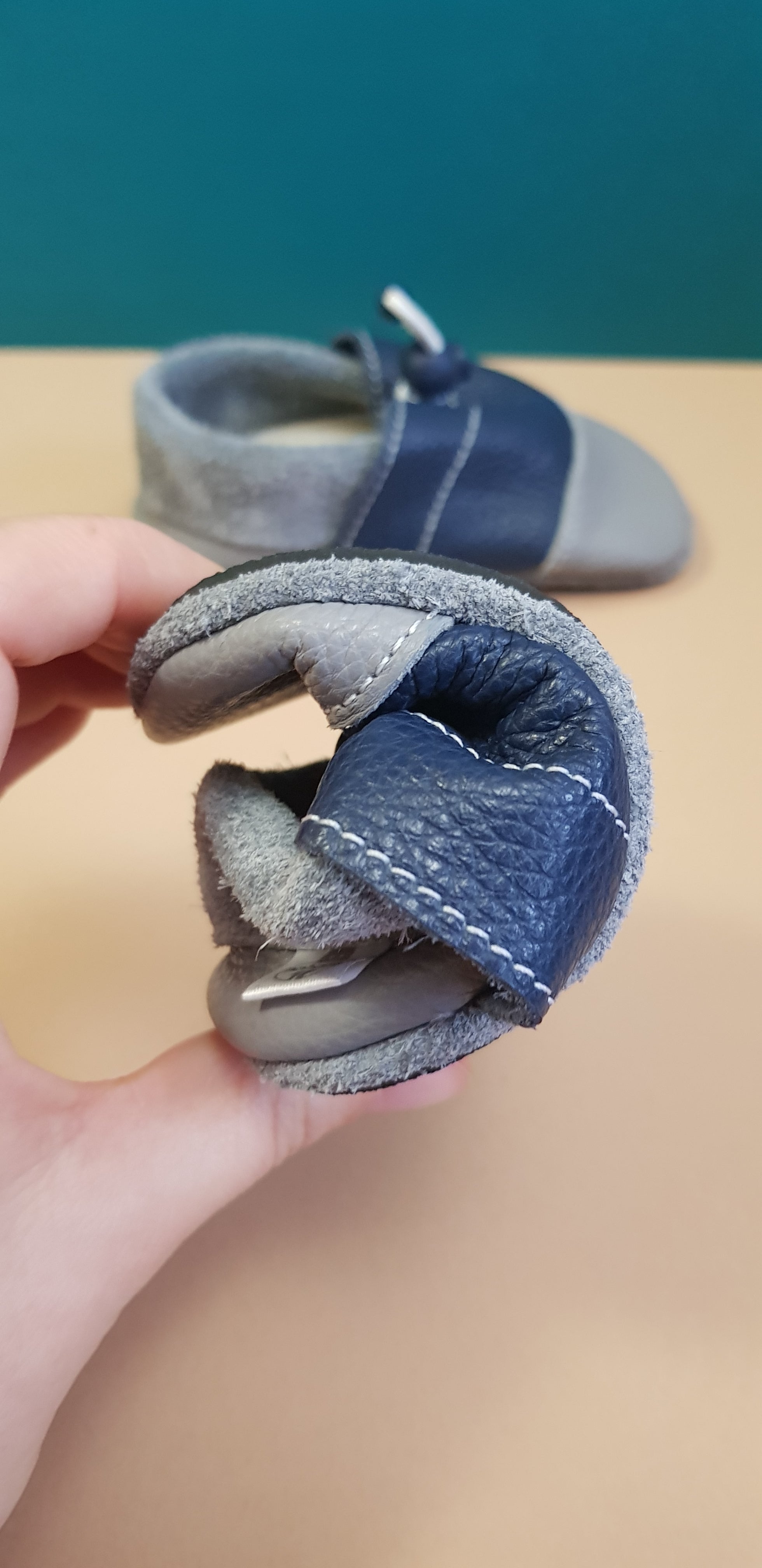 Bendable Navy and Grey Nohatka soft sole booties/slippers for babies and toddler, anatomically shaped from soft leather with adjustable ankle fastening and anti slip indoor/outdoor sole