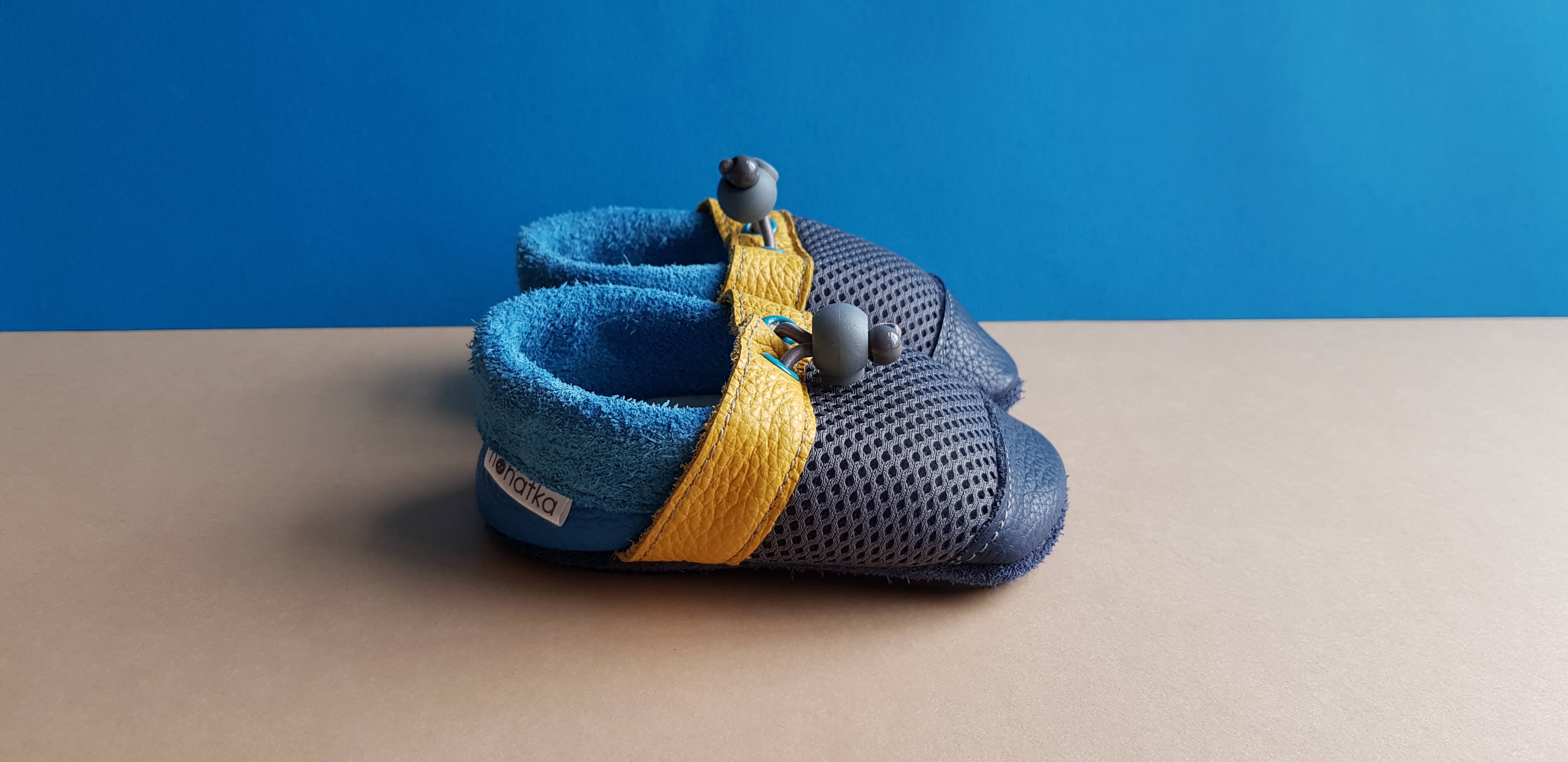 Yellow and Blue Nohatka soft sole booties/slippers for babies and toddler, anatomically shaped from soft leather with adjustable ankle fastening and anti slip indoor/outdoor sole